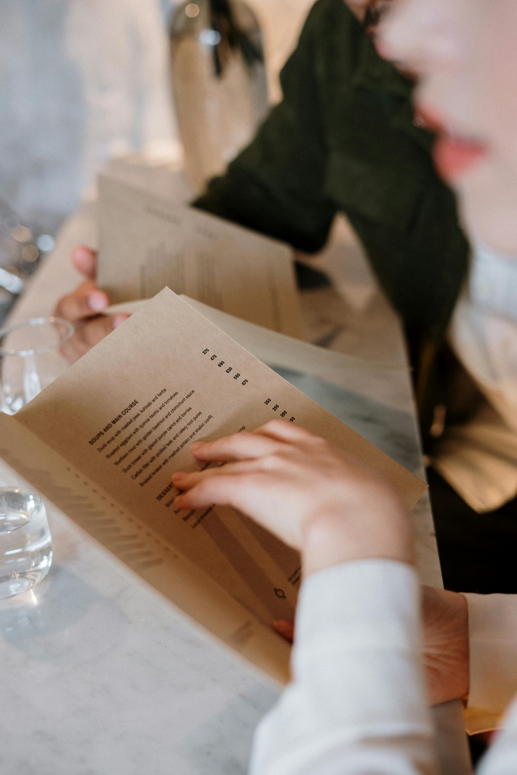 A couple explores menu options in a cozy restaurant setting, reflecting elegance and intimacy.